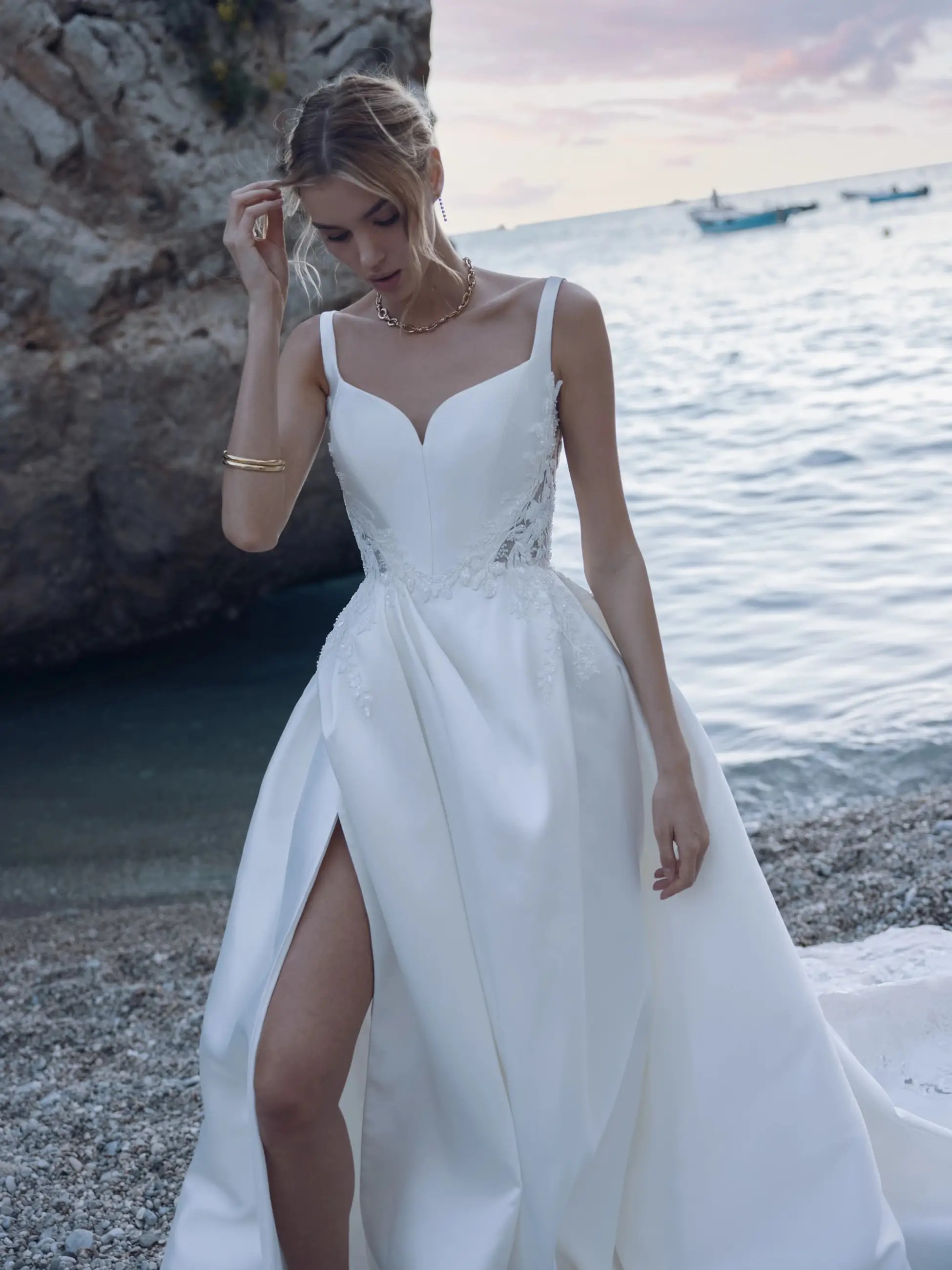 Photo of the model wearing a white bridal gown near the lake